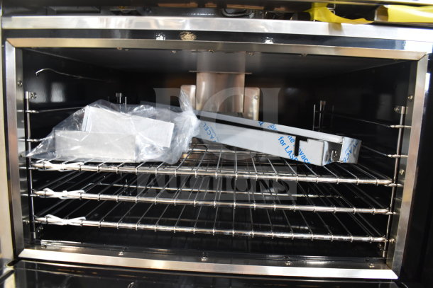 Interior view of the Imperial Range Pro Series oven with clean, stainless steel racks. New parts in packaging are visible inside.