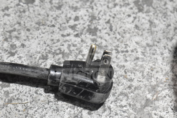 Black power plug of Scotsman W-HID207ABX-1A countertop water and nugget ice dispenser on gray surface, 115 volts.