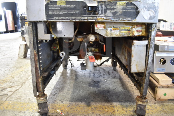 Henny Penny PFG-690 Computron 8000 pressure fryer, natural gas, 100,000 BTU, on casters, shows wear with visible caution labels.