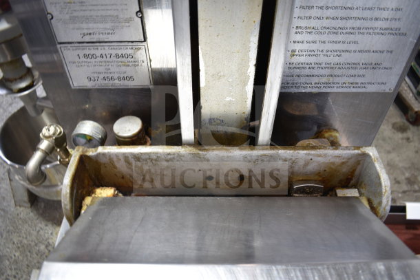 Henny Penny PFG-690 Computron 8000 pressure fryer, natural gas, on casters. Shows signs of use. Labels list maintenance tips.
