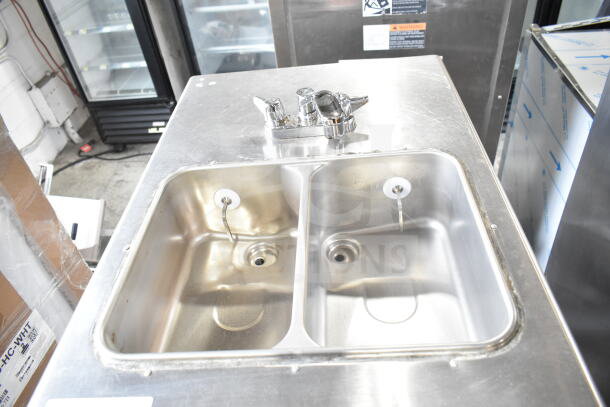 Taylor commercial water-cooled 2-flavor soft serve ice cream machine with twist feature on casters, stainless surface.