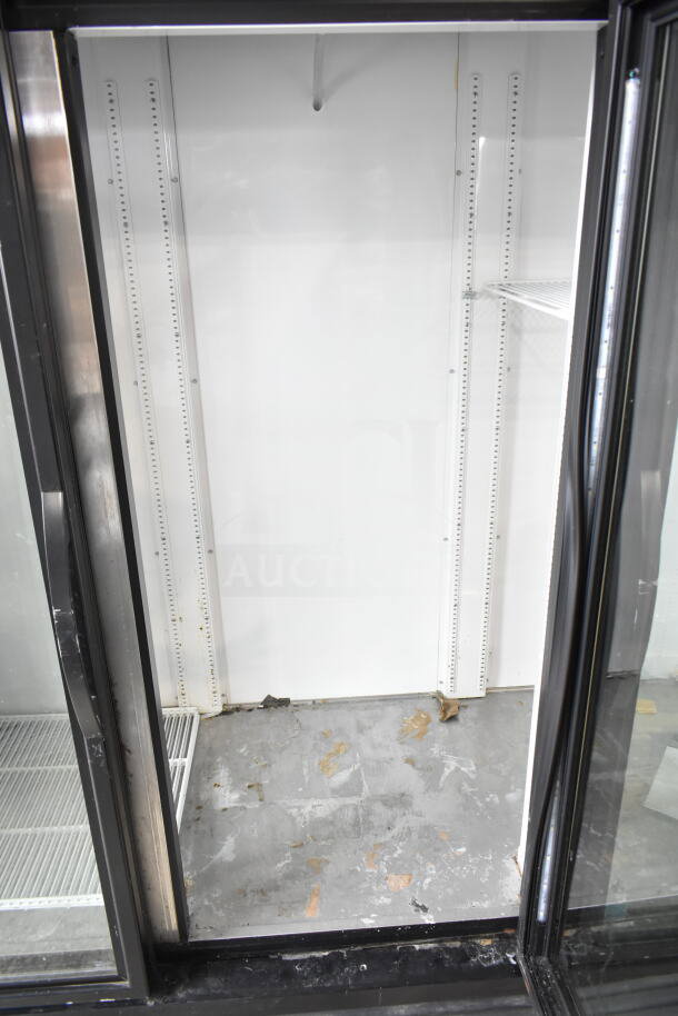 2019 True GDM-72-HC commercial 3 door reach-in cooler, 115V, 1 phase. Interior visibly worn, no shelves installed.