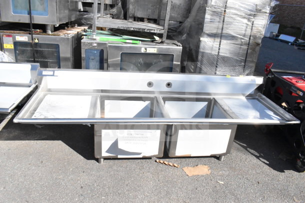 Alt text: "Regency 600S22424224 commercial 2 bay sink with dual drain boards, scratch and dent, new condition, visible labels."