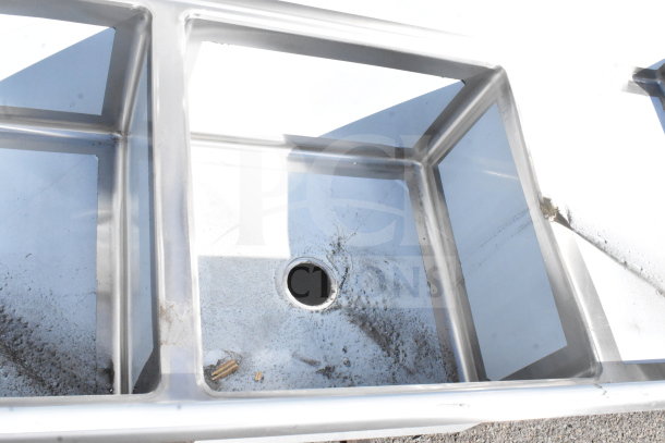 BRAND NEW SCRATCH AND DENT Regency 600S32424218 commercial 3 bay sink with dual drain boards, no legs visible.