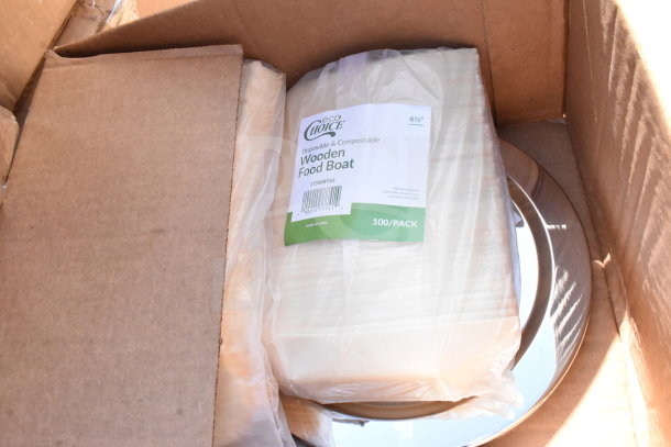 Box of brand new scratch and dent items including EcoChoice wooden food boats and melamine plates, visible packaging.