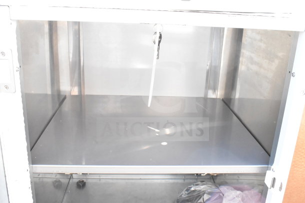 Brand new commercial cabinet with scratches and dents, stainless steel interior, includes keys, ideal for storage.
