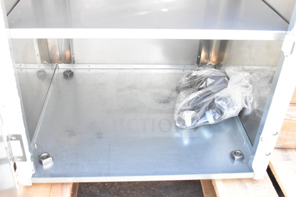 Brand new scratch and dent commercial cabinet, stainless steel, interior view, included parts in plastic wrap, minor blemishes.