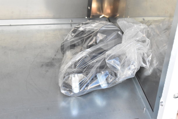 Brand new scratch and dent commercial cabinet interior, showing hardware in plastic wrap.