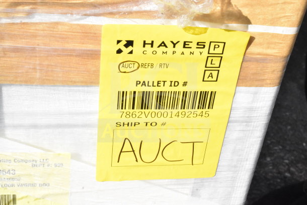 Hayes Company security case with yellow tag, marked "AUCT," pallet ID 7862V0001492545, visible scratch and dent.