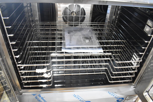 Brand new Vulcan VC4ED-11D1 convection oven, 208V, with view-through doors and racks. Manual visible inside.