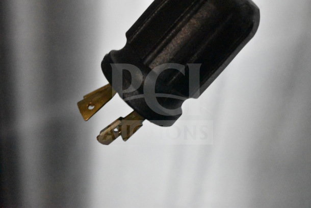 Close-up of a plug from a True GDM-472F-HC Commercial Freezer, showing three prongs for 115/208-230 Volts, 1 Phase.