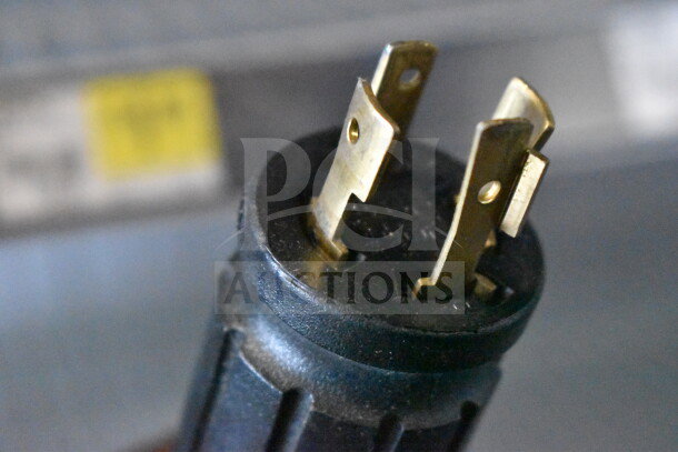 Close-up view of a plug for the 2019 True GDM-472F-HC commercial freezer, showing prongs and part of the cord.