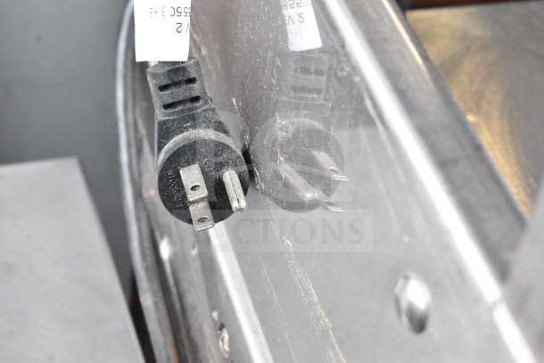 Black plug of the 2017 Delfield UCD4464N-12-DD5 prep table; 115 volts, shown against reflective metal surface.