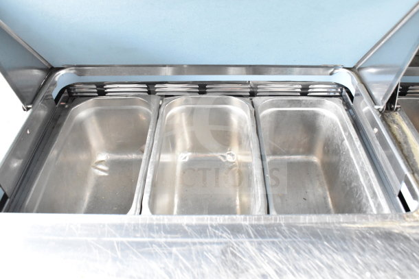 2017 Delfield UCD4464N-12-DD5 prep table bain marie with open top view, stainless steel trays, good condition.