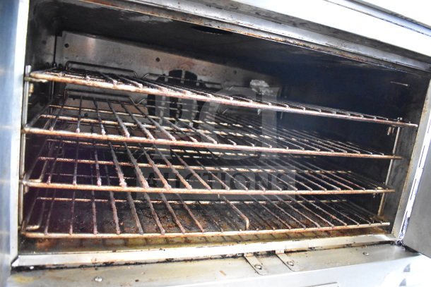 Southbend commercial convection oven interior with multiple racks, showing used condition, part of flat top griddle unit.