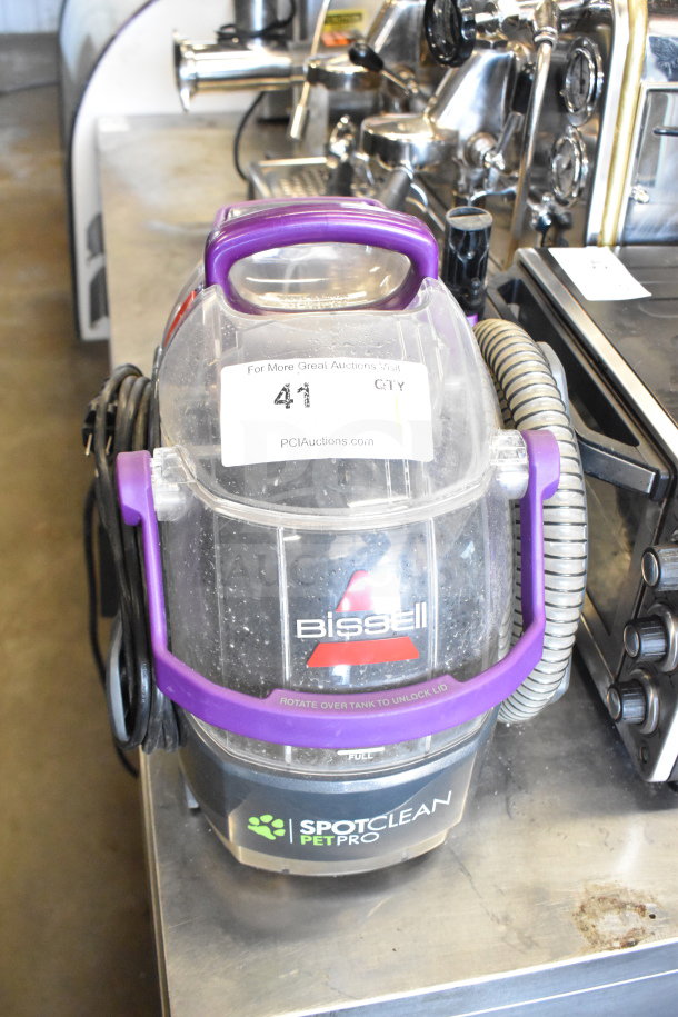 Bissell 2458 SpotClean PetPro Vacuum Cleaner. Purple handle, visible tank, includes cord and hose. Model label shown.
