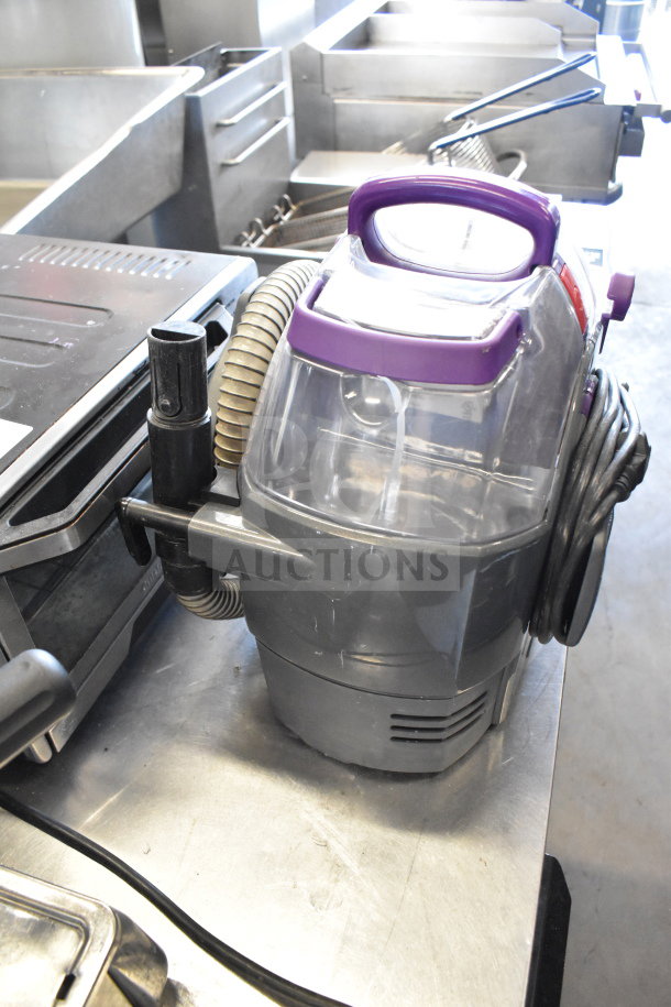 Bissell 2458 SpotClean PetPro Vacuum Cleaner with purple handle, visible hoses, in used condition, 115 Volts, 1 Phase.