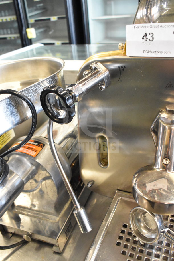 Faema E61 2-group espresso machine with 2 portafilters and steam wand, stainless steel, good condition, auction tag visible.