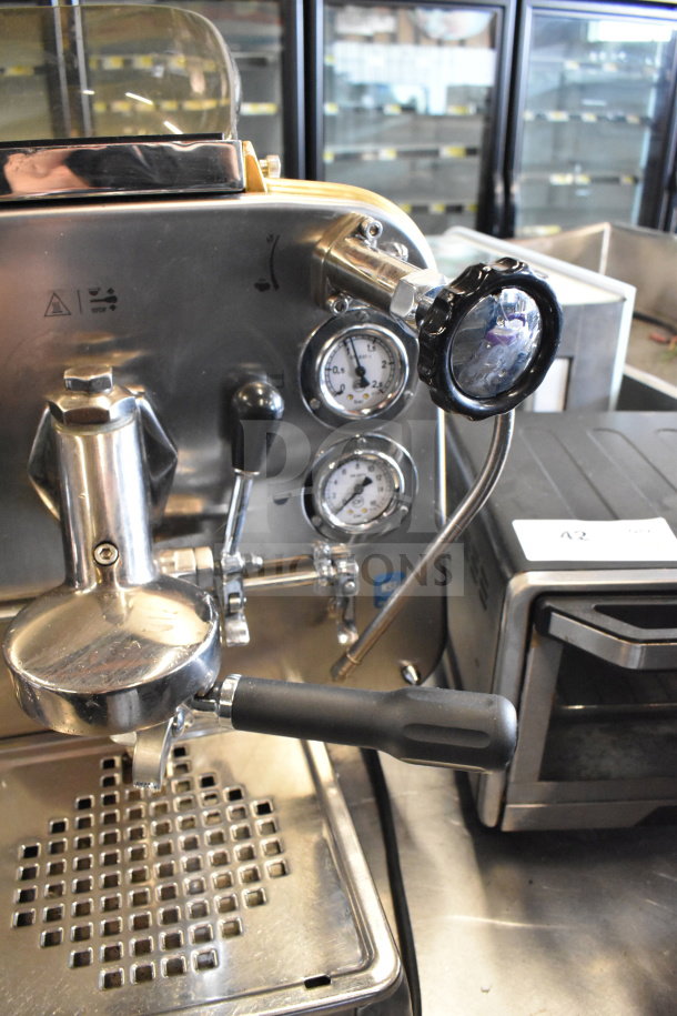 Faema E61 commercial 2 group espresso machine with 2 portafilters, steam wand, and visible gauges; stainless steel body.