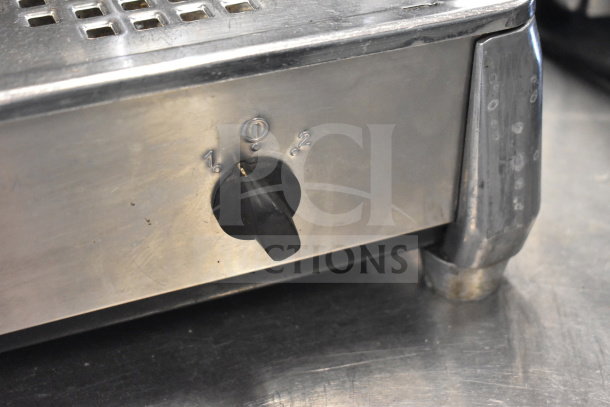 Faema E61 espresso machine side view showing metal exterior with a black knob and numbered settings.