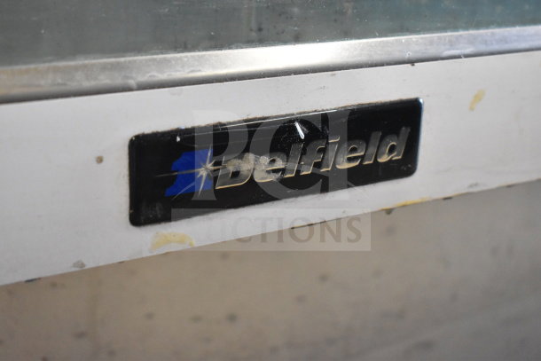 Delfield Commercial Deli Display Case with visible brand label, showing some wear. Ideal for merchandising deli items.