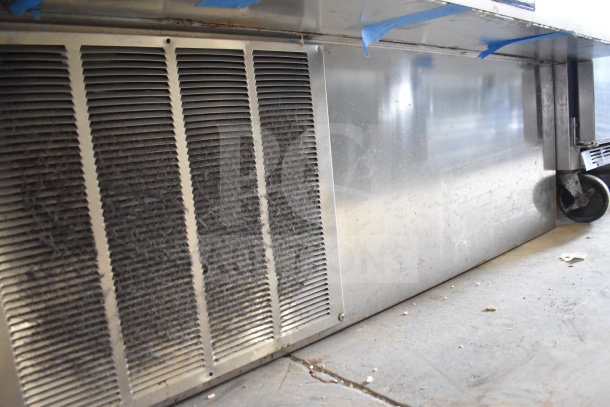 Delfield Commercial Deli Display Case, floor style, stainless steel, visible dust on vents, minor wear, caster wheel.