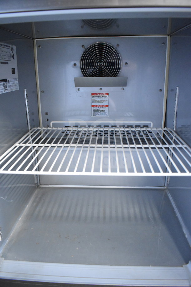 Beverage Air WTRF48A-1-SA-A undercounter freezer interior with wire shelf and visible fan, label shows electrical safety warnings.