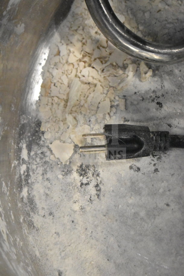 Commercial spiral dough mixer with mixing bowl, bowl guard, and dough hook attachment. Used condition, visible flour residue.