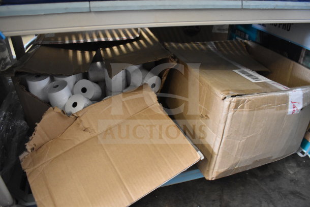 Boxes of receipt printer rolls, partially opened, showing multiple rolls inside. Rolls in original packaging.