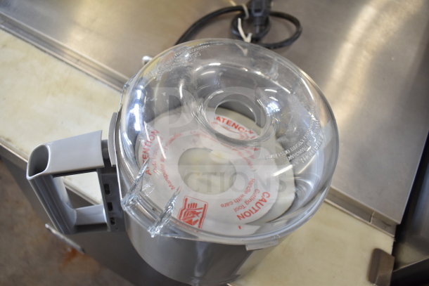 Robot Coupe R2 commercial countertop food processor with clear lid and caution labels, includes blades, in good condition.