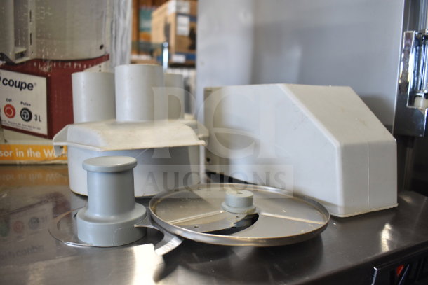 Robot Coupe R2 commercial food processor with blades, in good condition, showing attachments and original packaging.