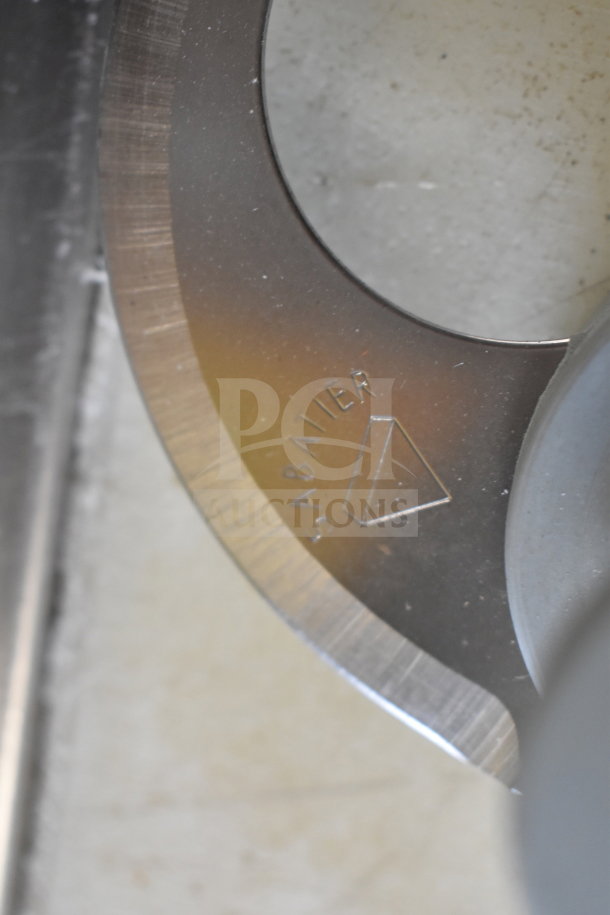 Close-up of a sharp, metallic blade for a Robot Coupe R2 Commercial Food Processor; engraved with "Sabatier" marking.