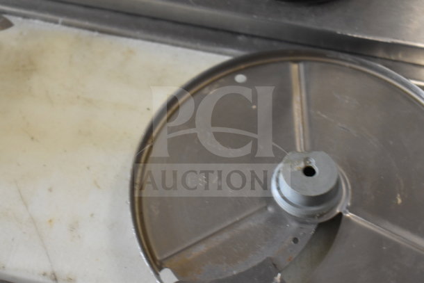 Robot Coupe R2 food processor blade, metal, showing wear; part of commercial countertop processor set.