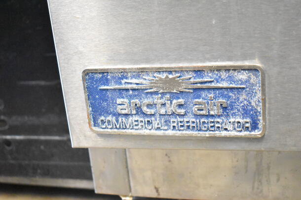 Arctic Air AMT28R commercial prep table label, indicating make and model. Stainless steel surface, visible wear.