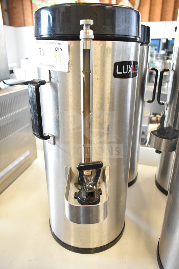 2 Fetco TPD-15 Luxus beverage dispensers, stainless steel, visible Luxus logo, includes handles and spouts, used condition.