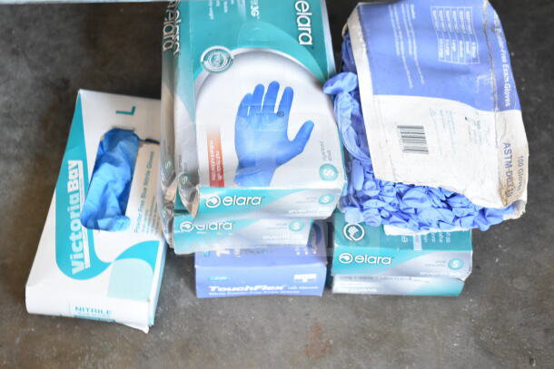 Two-tier lot of disposable gloves in boxes, featuring brands like Victoria Bay and Elara. Various sizes and materials.