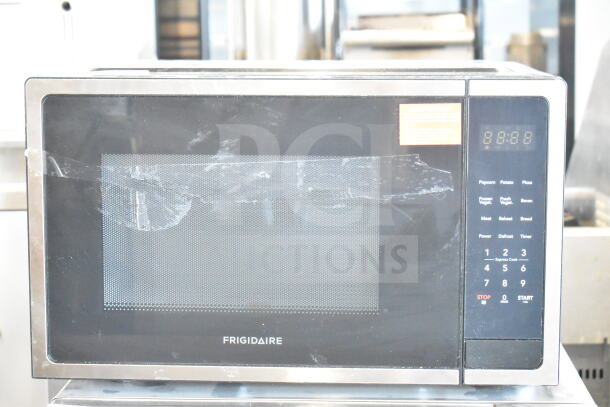 Frigidaire EMW1510 countertop microwave oven, black and stainless steel, 120 volts, 1 phase, visible wear on door.