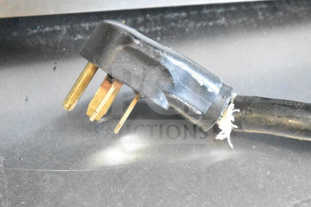 Close-up of a 3-prong power plug for a Fri-jado TDR 7-P rotisserie oven, showing wear on the cord.