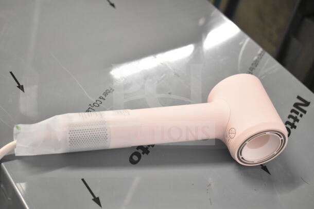 Pink hair dryer with cut power cord, cylindrical shape, no visible brand, part of six-item auction lot.