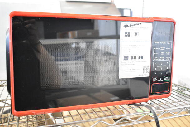 Hamilton Beach MS8436127995-02 countertop microwave oven with red trim. Model label visible. Door does not open. 120V, 1 phase.