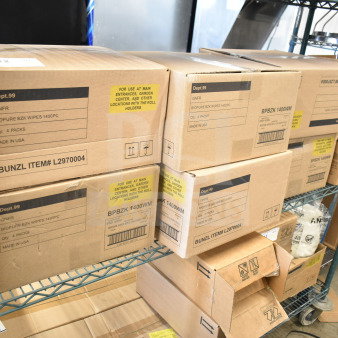 Boxes of GNFR Biopure BZK Wipes, 1400 pieces per pack, non-corrosive lime scale remover, on a metal shelf.