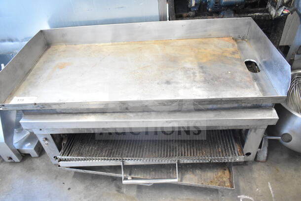 Commercial countertop flat top griddle with cheese melter, stainless steel, used condition, visible surface wear.