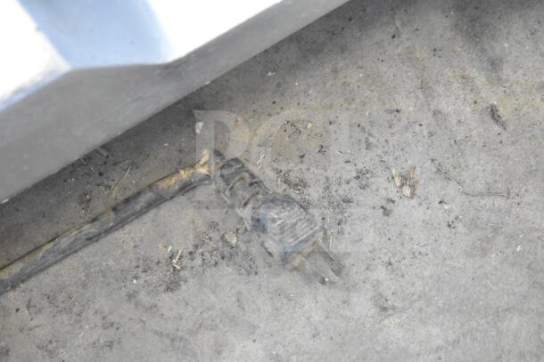 Fleetwood BF 300 meat slicer plug on dirty concrete. 115 volts, damaged insulation visible.