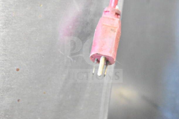 Red electrical plug connected to a metal surface, part of Groen Commercial Steam Cabinet setup, showing potential wear.