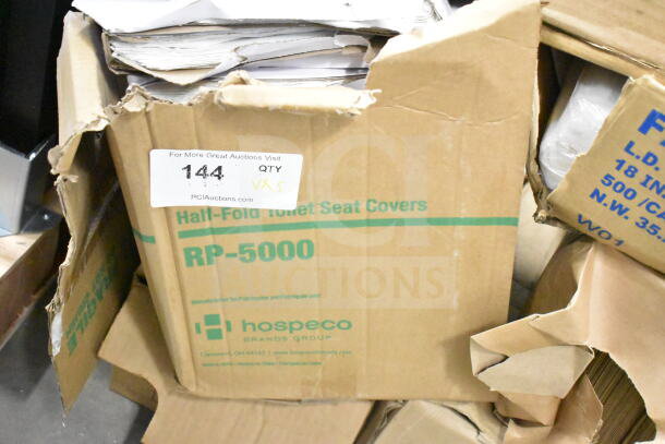 Cardboard boxes containing RP-5000 Half-Fold Toilet Seat Covers by Hospeco, showing packaging detail and auction tag reading "144 QTY x5".