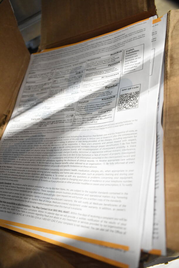 Box filled with documents and papers showcasing various language translations and communication notices.