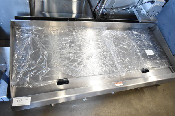 BRAND NEW Scratch and Dent Cooking Performance Group GT-CPG-60-NL 60" natural gas griddle with plastic wrap and safety warning label.