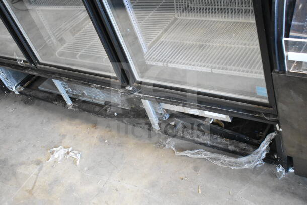 True GDM-72F-LD commercial 3-door reach-in freezer merchandiser; visible wear, shelves intact, 115/208-240V, 1 phase.
