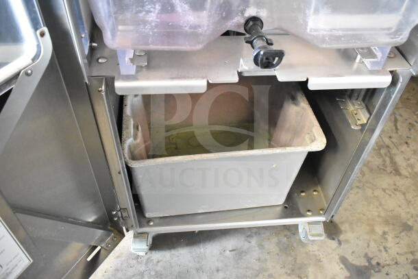 LATE MODEL JBT 2ND-GEN-MFJ-HE citrus juicer, commercial floor style, on casters, showing open compartment.