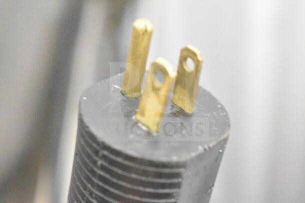 Close-up of a power plug for a JBT Fresh N Squeeze citrus juicer, 115 volts, 1 phase, showing three brass prongs.